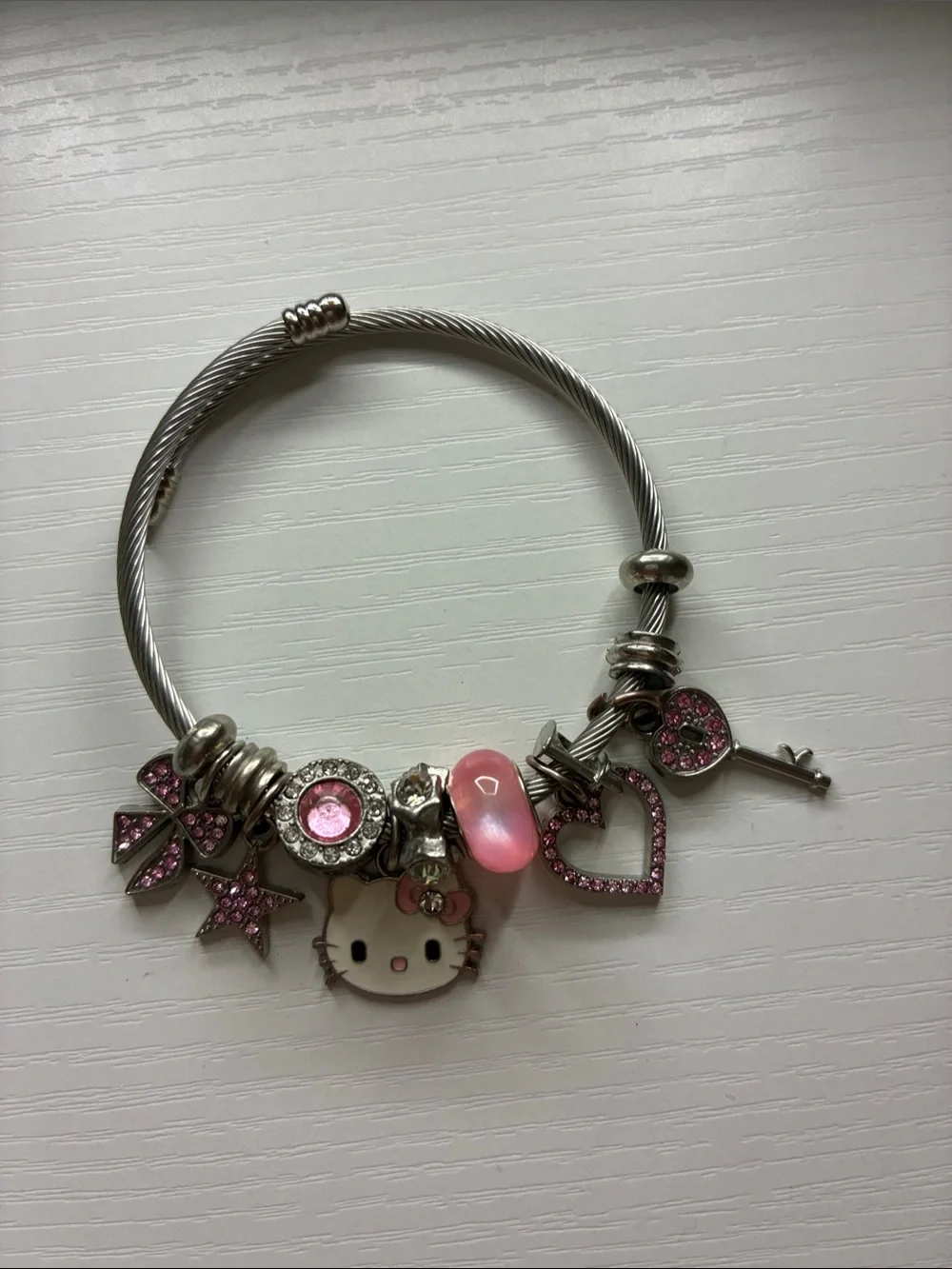 Hello kitty bracelet with pink charms and gems.